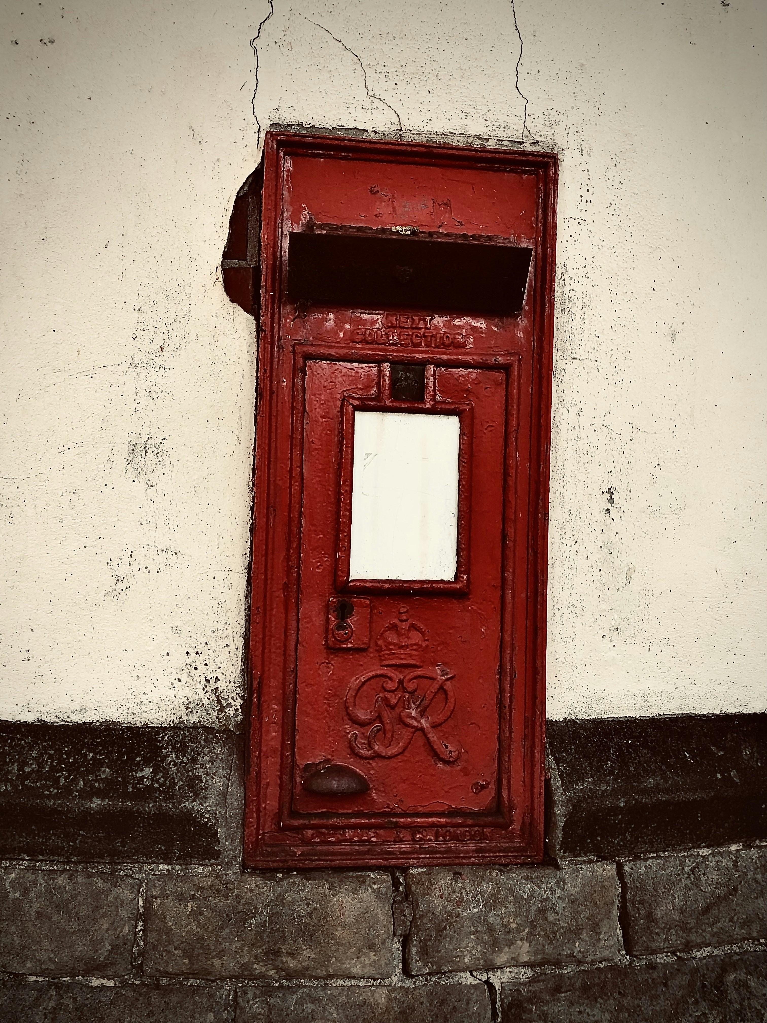 A red mailbox sitting on the side of a building