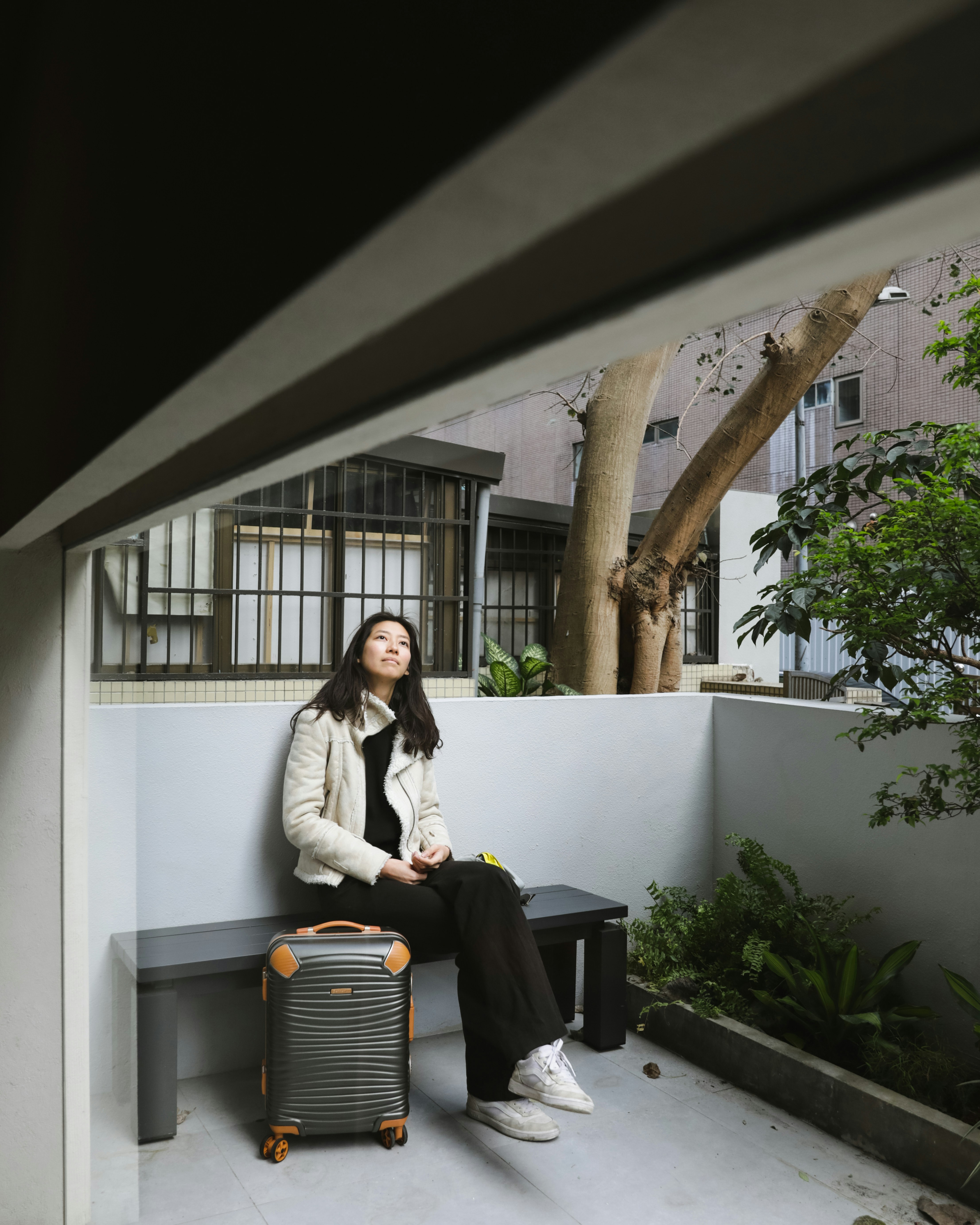 um, mulher, sentando, ligado, um, banco, ao lado, um, mala de viagem