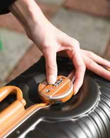 A person pushing a button on a suitcase