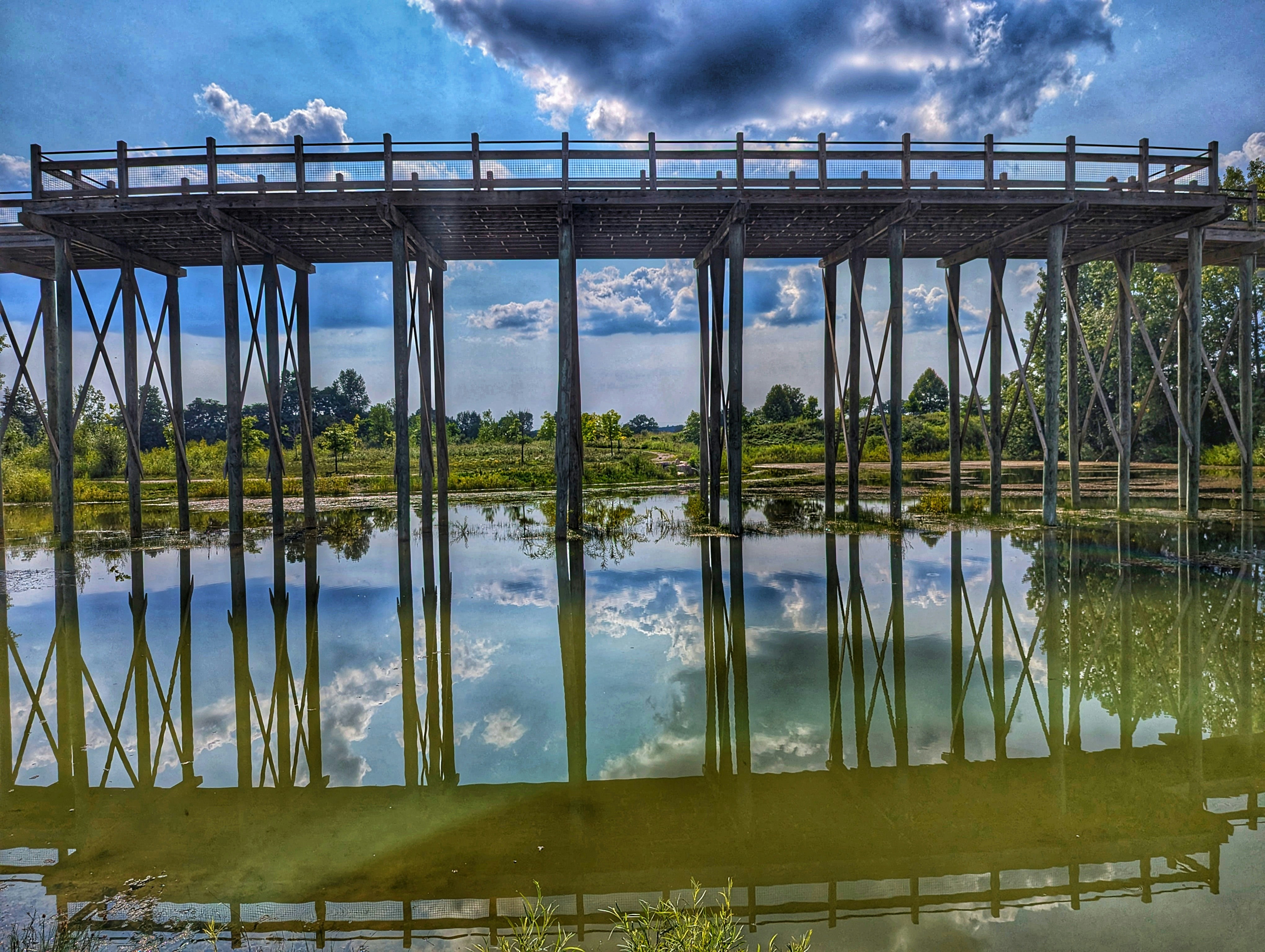 Un ponte su uno specchio d'acqua sotto un cielo nuvoloso