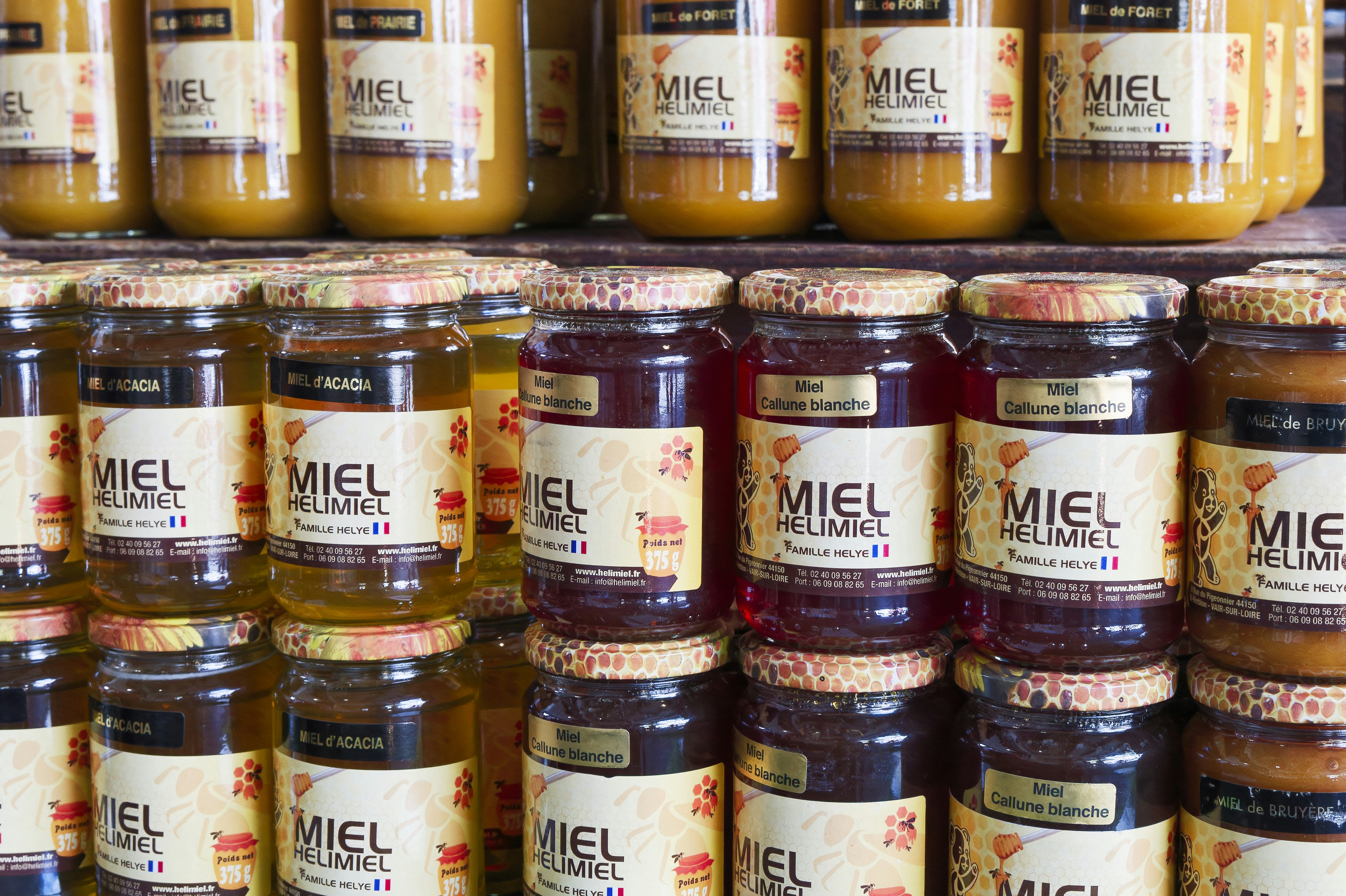 Jars of honey sit on a shelf in a store