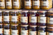 Jars of honey sit on a shelf in a store