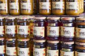 Jars of honey sit on a shelf in a store