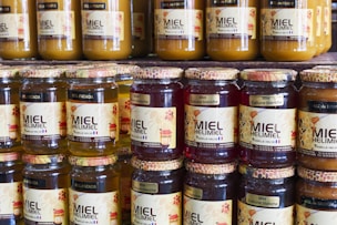 Jars of honey sit on a shelf in a store