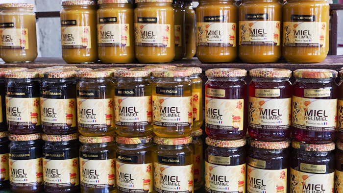 Rows of small-batch jars from local food makers lined up on a wooden shelf.