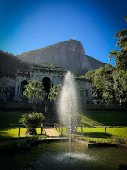 A fountain in a park with a mountain in the background