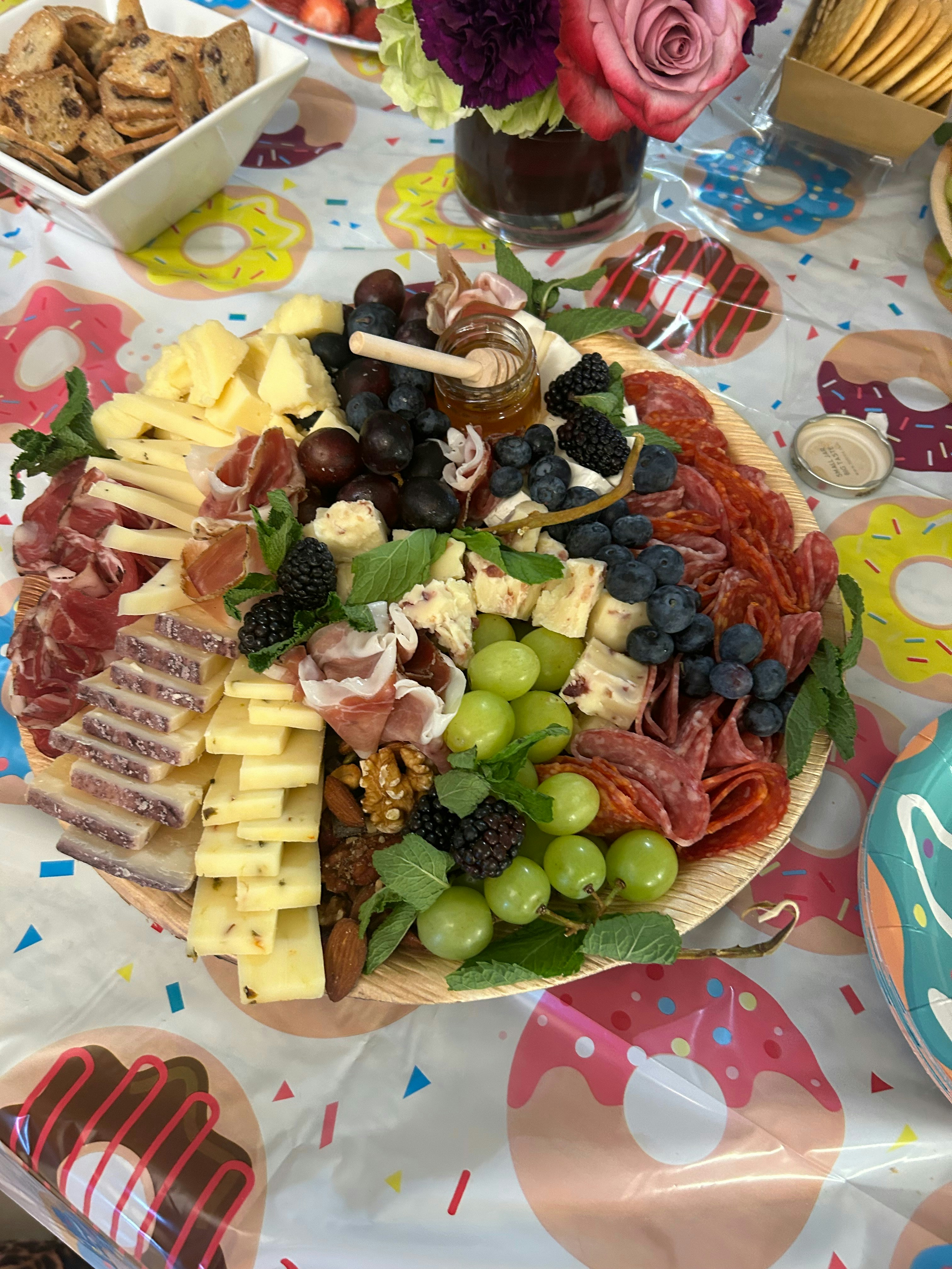 A large platter of cheese, meats, and grapes
