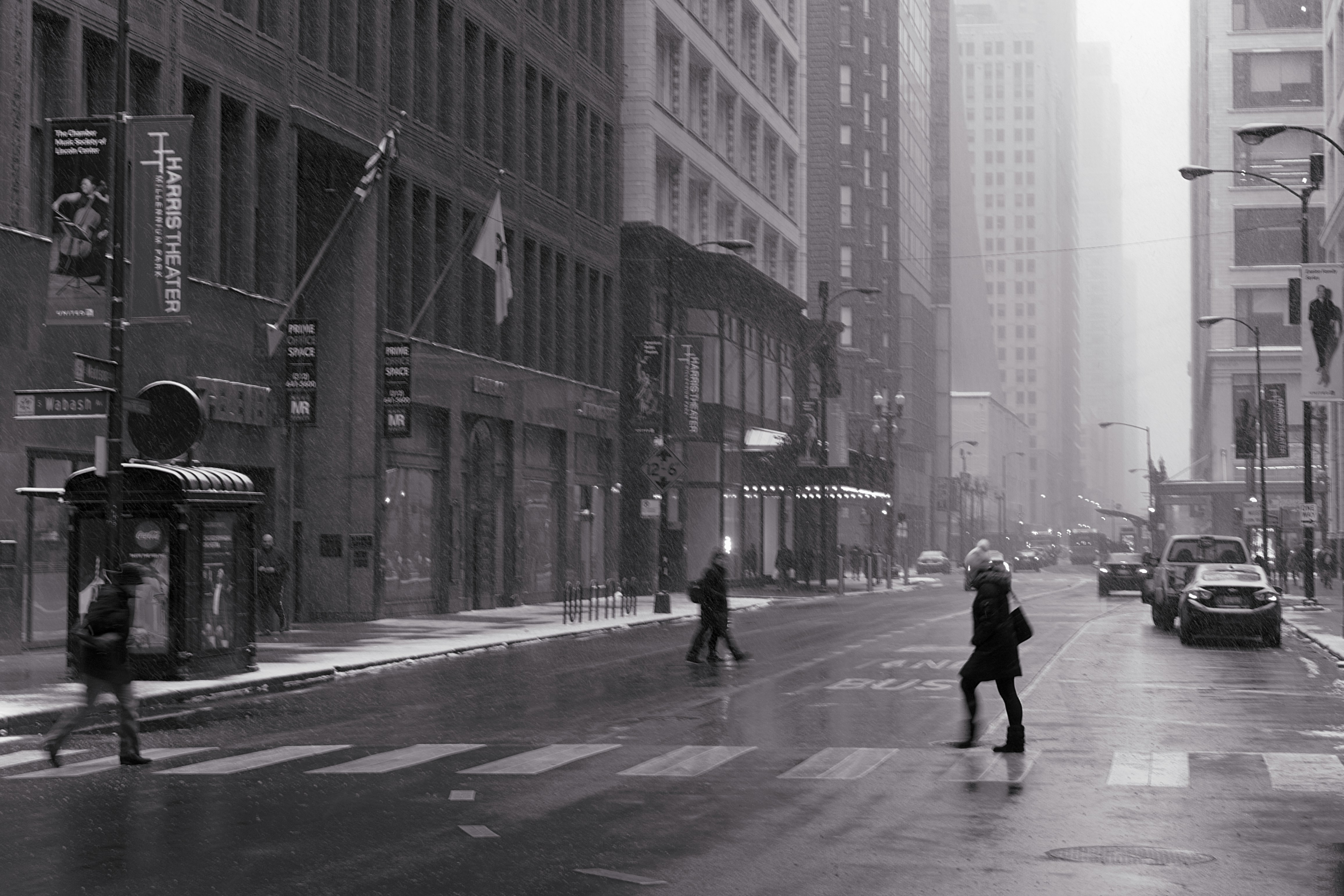 A black and white photo of people crossing the street