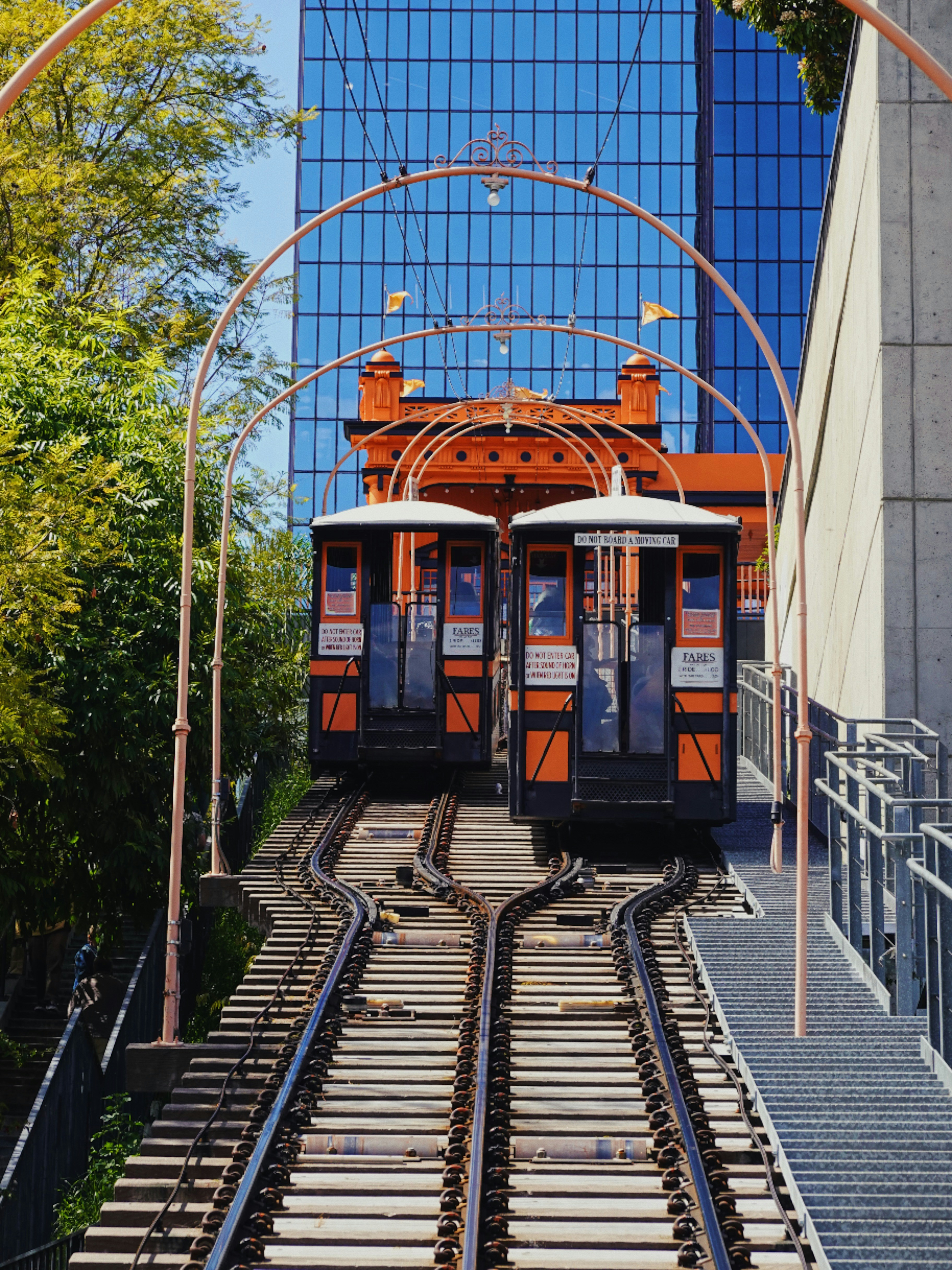 A train traveling down tracks next to a tall building