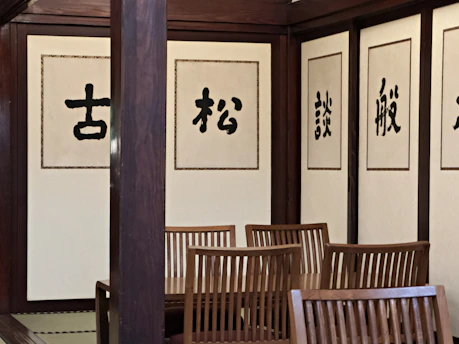 A room with a lot of chairs and paintings on the wall