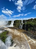 A waterfall with a rainbow in the middle of it