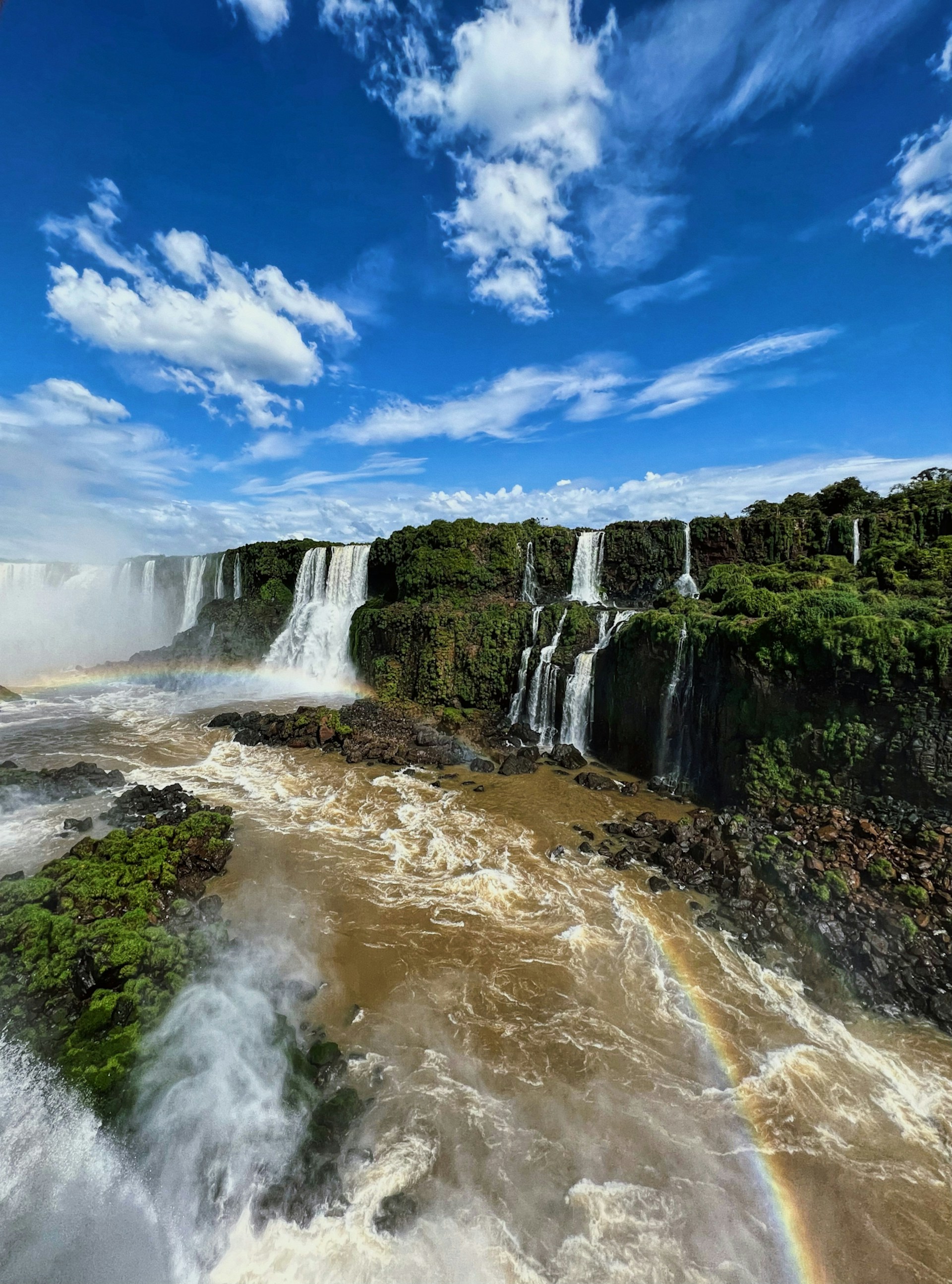 A waterfall with a rainbow in the middle of it