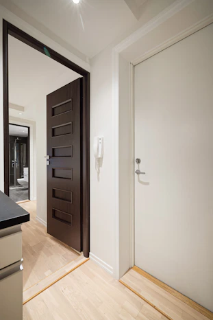 A kitchen with a black counter top and a white door