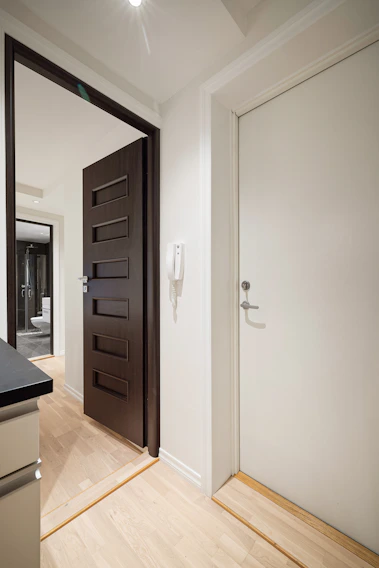 A kitchen with a black counter top and a white door