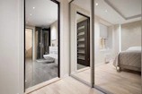 A bedroom with a large mirror and a bed