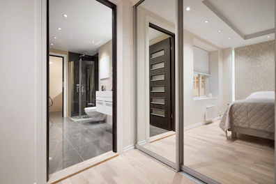 A bedroom with a large mirror and a bed