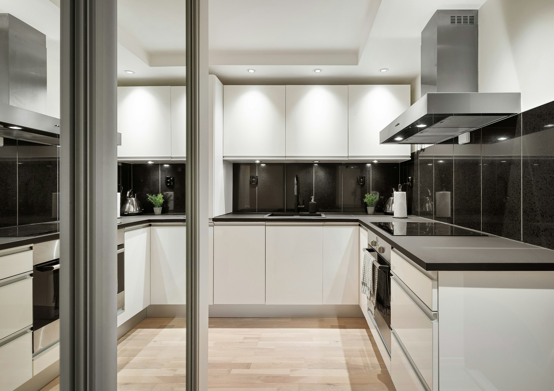 A kitchen with white cabinets and black counter tops