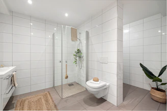 A bathroom with a toilet, sink, and shower