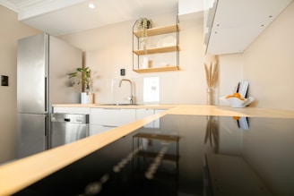 A kitchen with stainless steel appliances and a black counter top