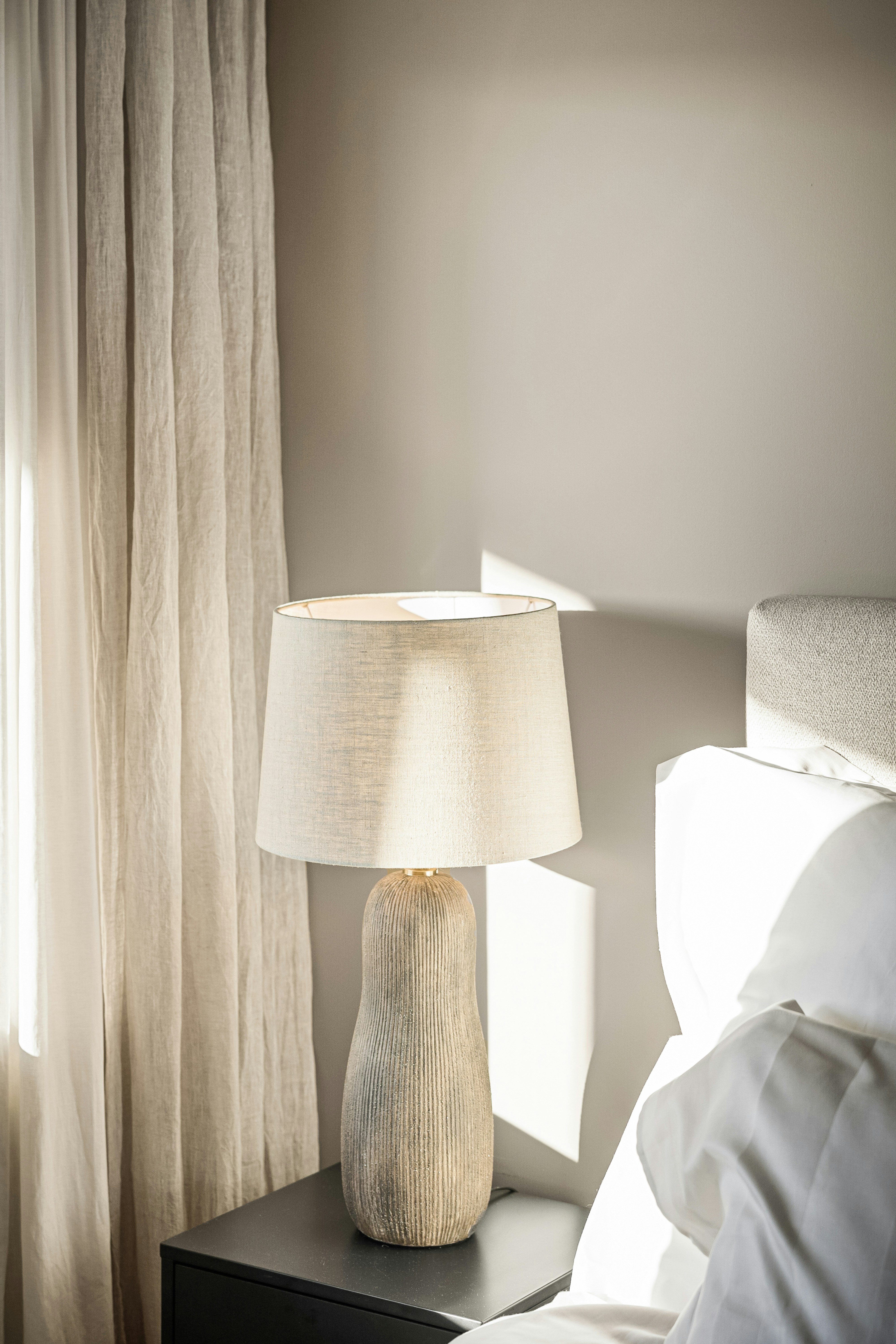 A bedroom with a lamp and a bed