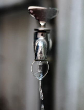 A water faucet with water dripping from it