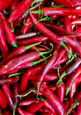 A pile of red peppers sitting next to each other