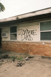 A house with graffiti written on the side of it