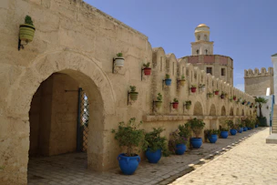 A stone building with blue potted plants in front of it