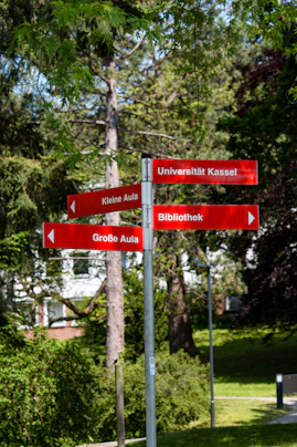 A red street sign sitting on the side of a road