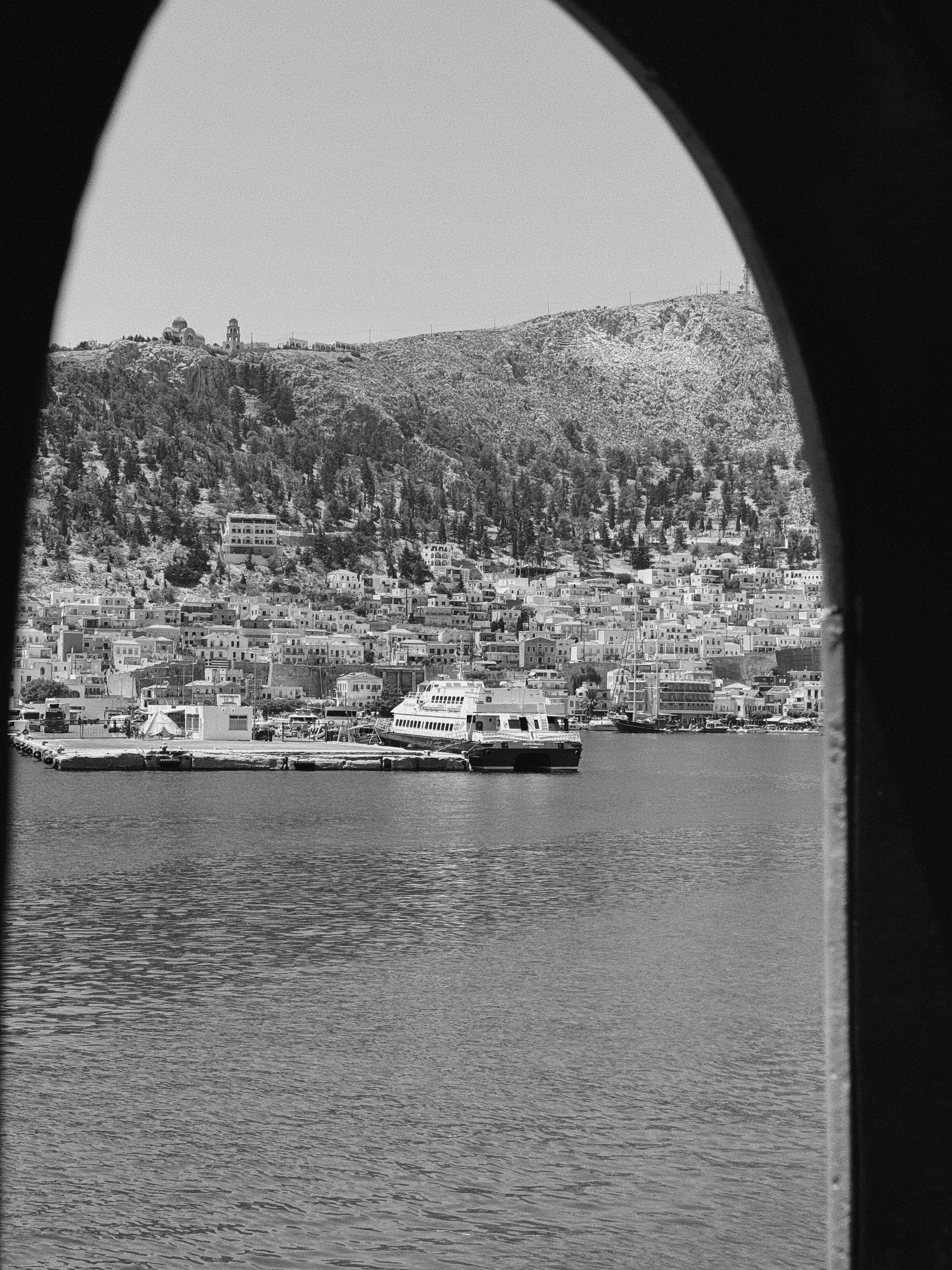 A black and white photo of a harbor with boats
