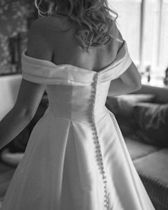 A woman in a wedding dress standing in a living room