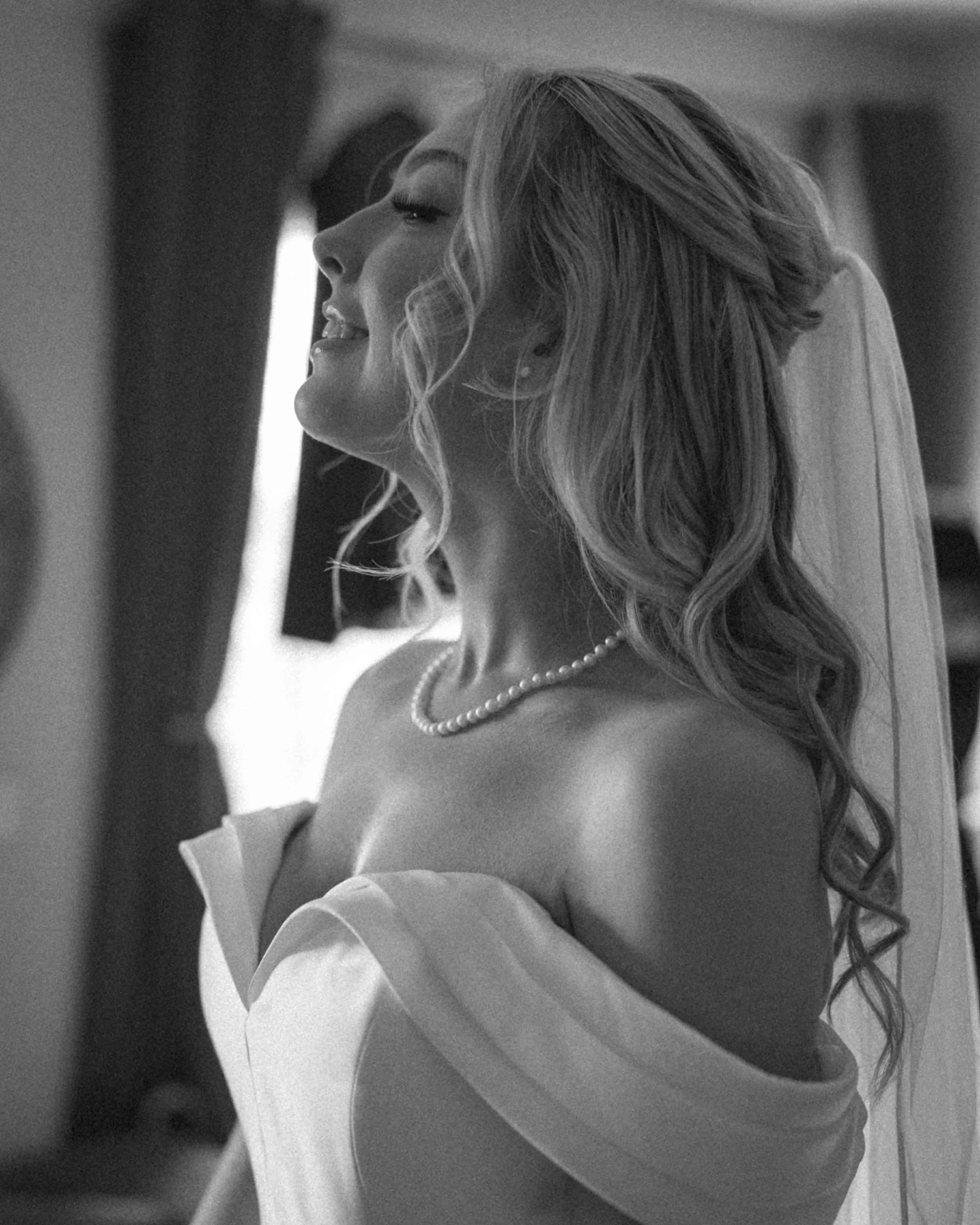 A woman in a wedding dress standing in front of a mirror