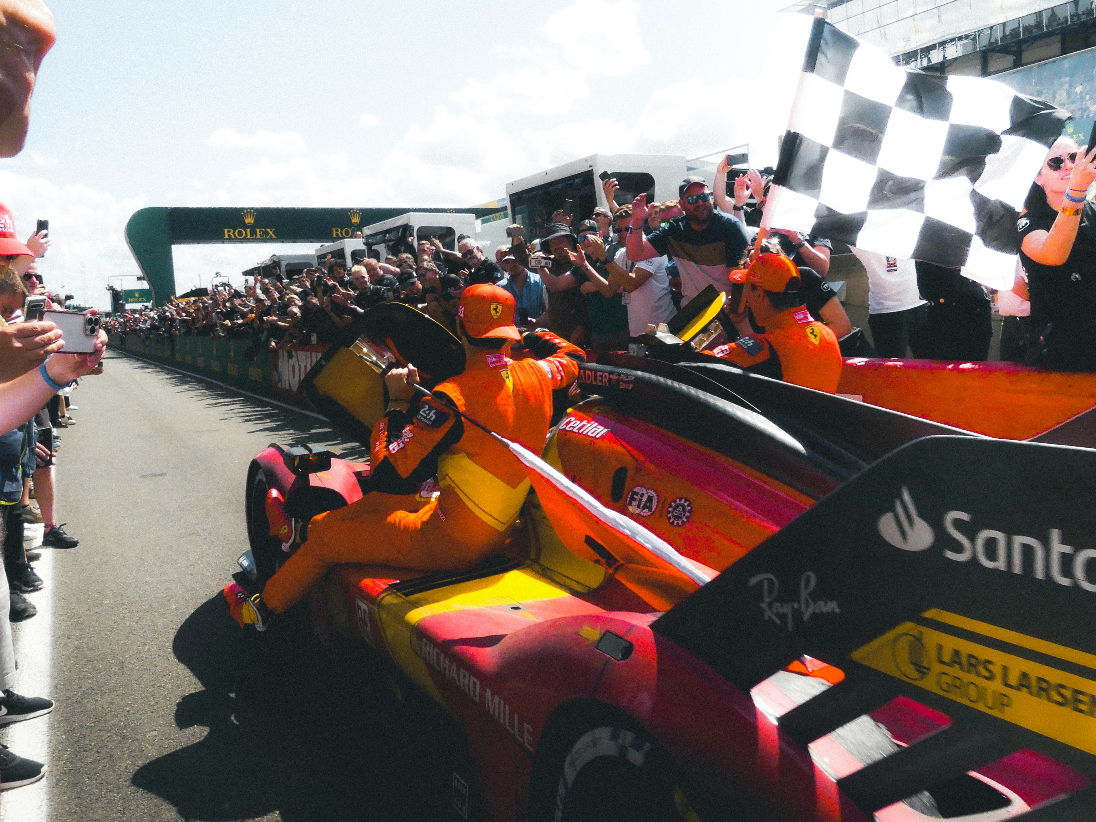 A group of people riding on top of a race car