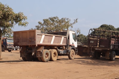 A couple of trucks that are sitting in the dirt