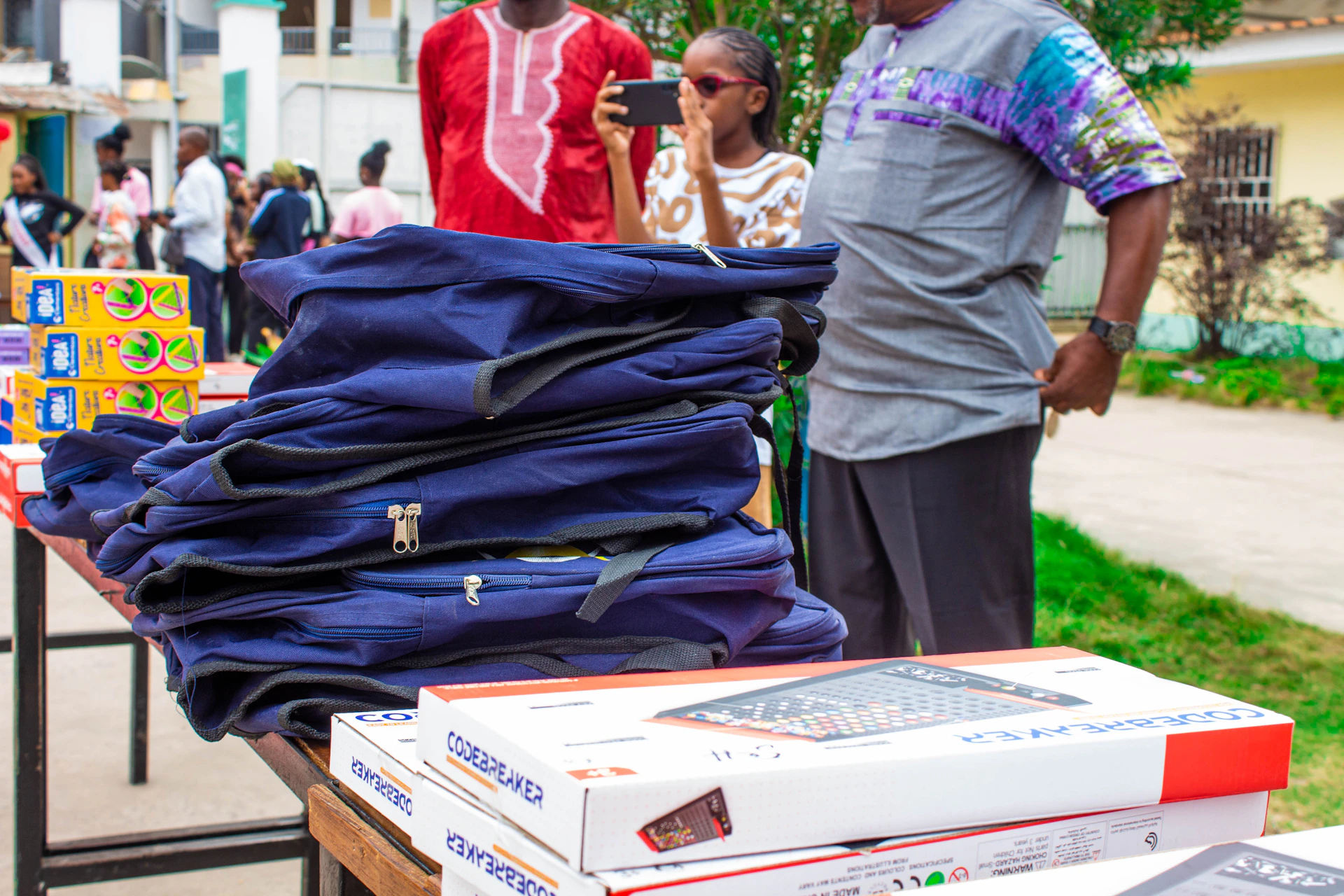 A group of people standing around a table with a bunch of shirts on it