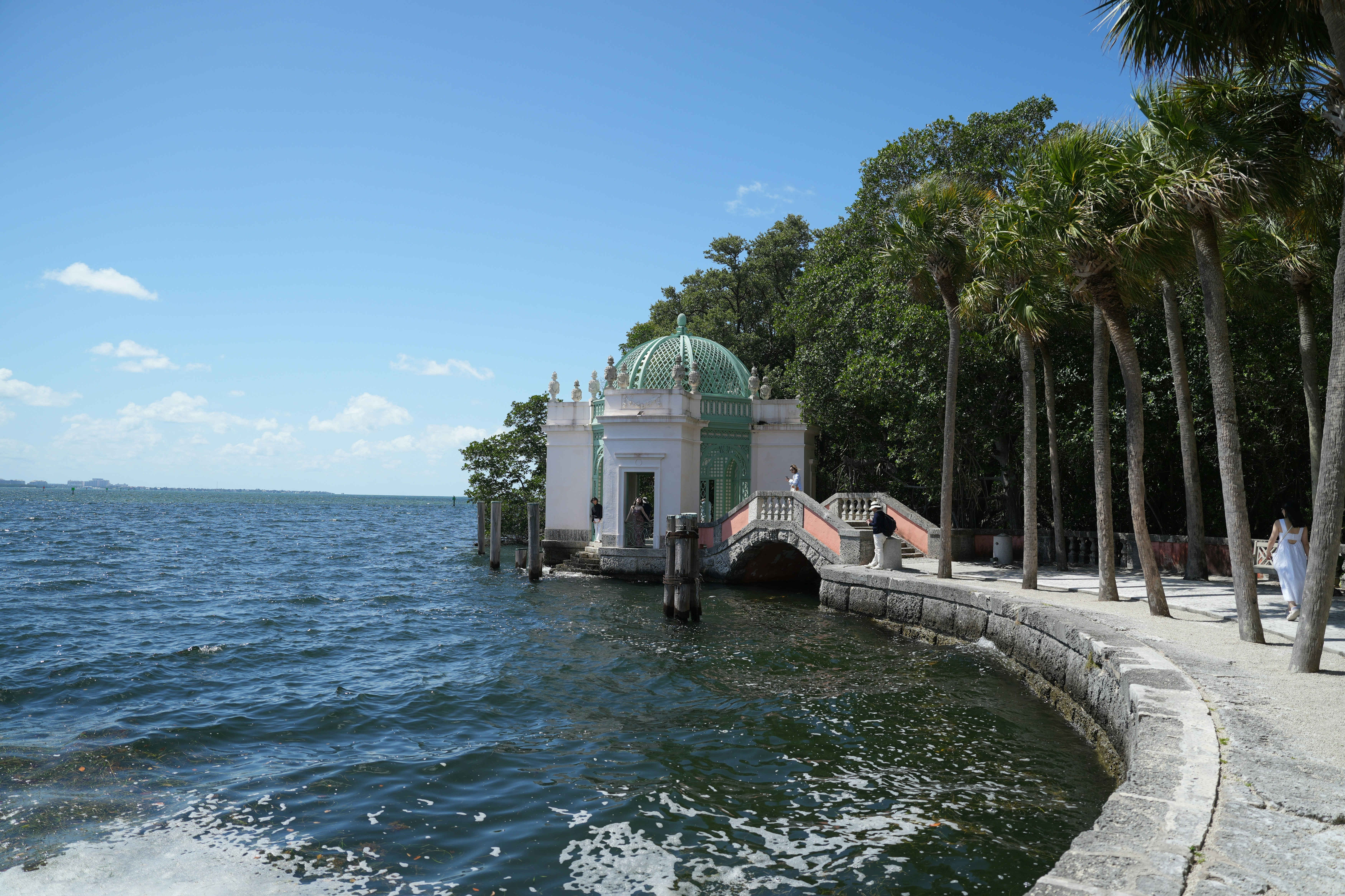A boat traveling down a body of water next to palm trees