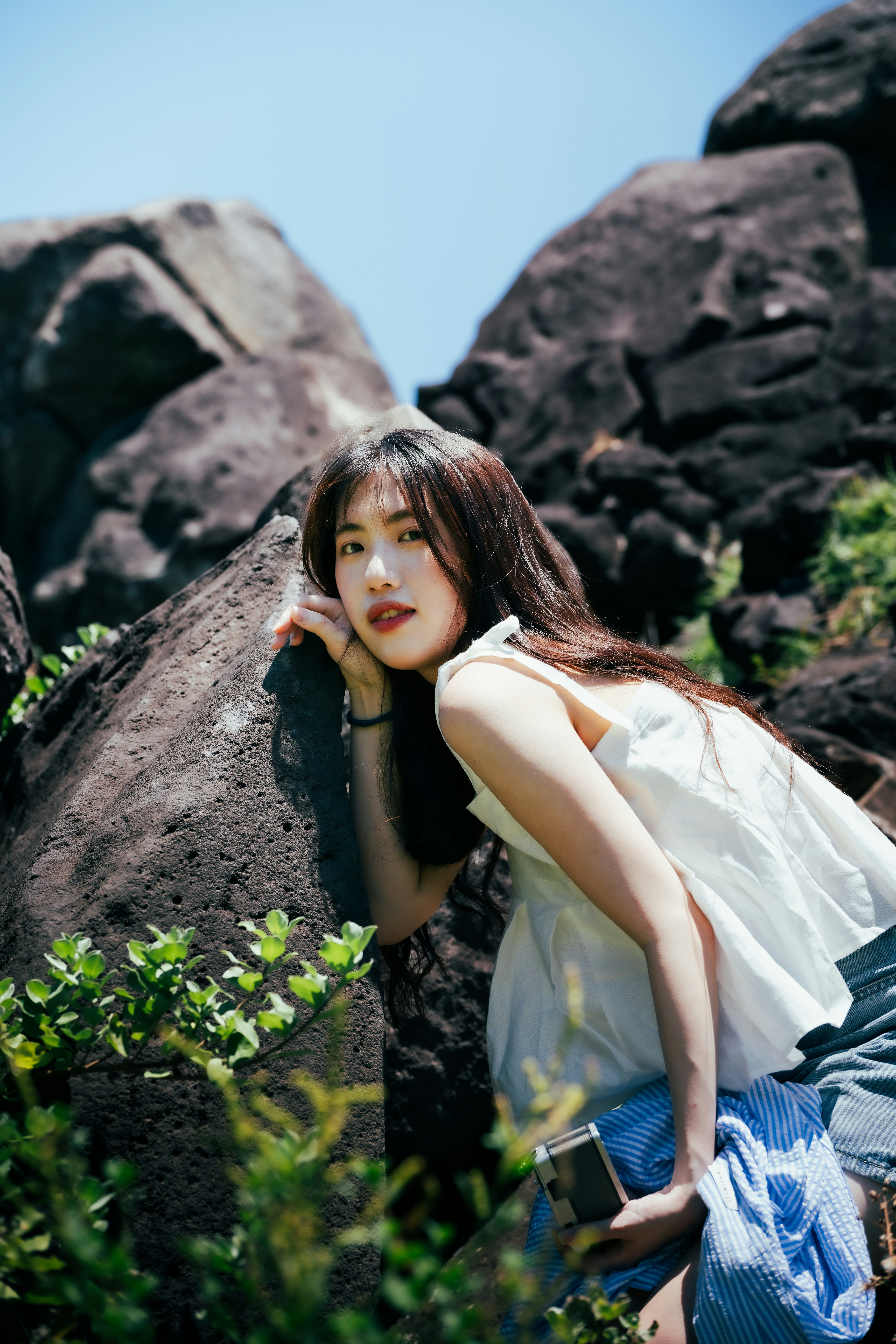 들판의 바위에 기대어 있는 여자