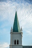 A tall white building with a green steeple