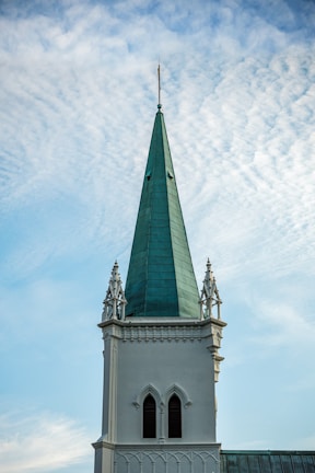 A tall white building with a green steeple