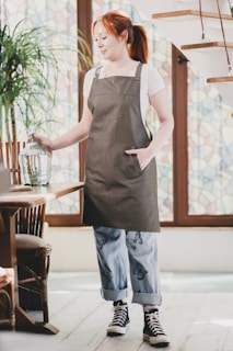 A woman in an apron holding a bird cage