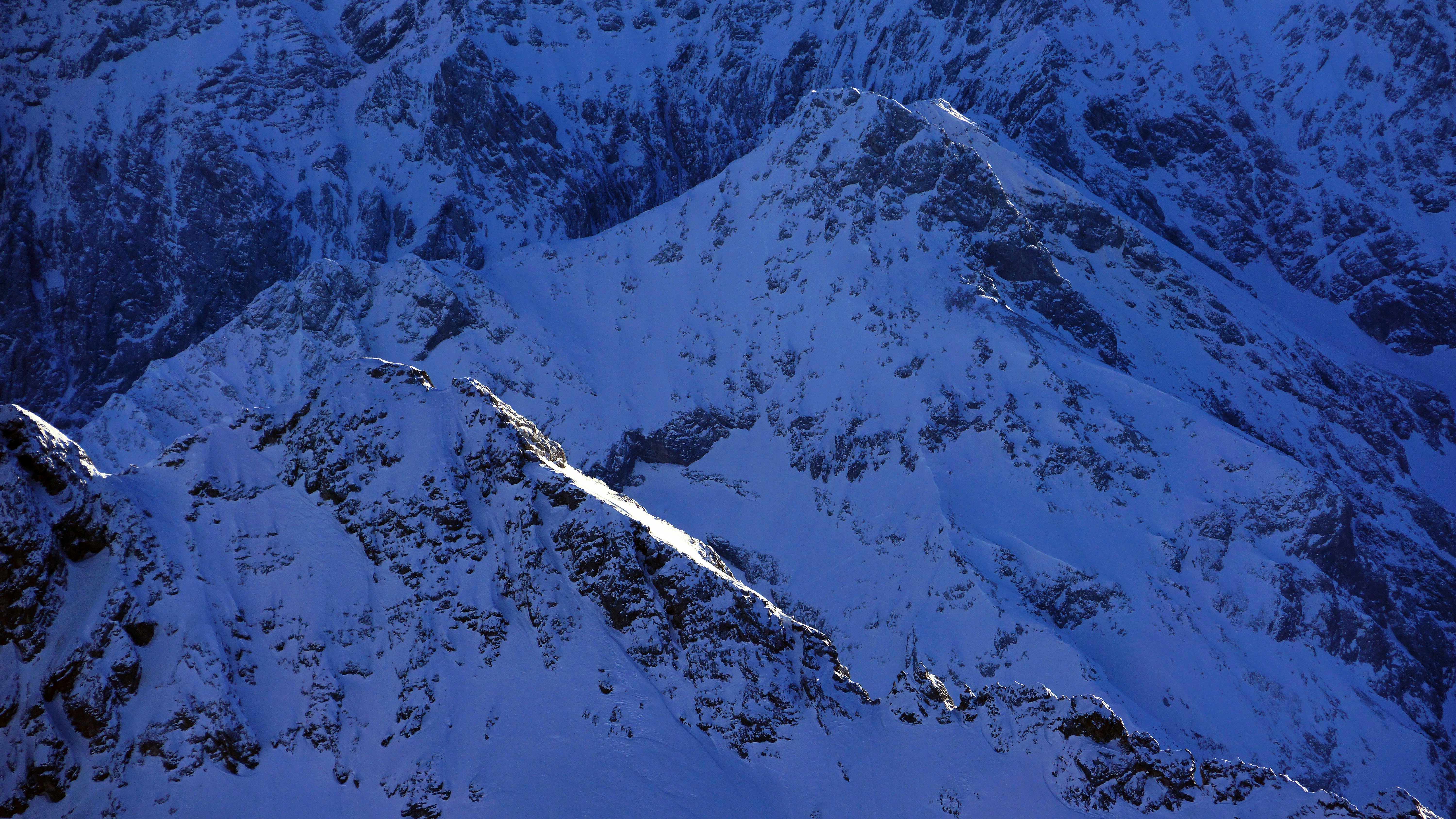 A snow covered mountain with a blue sky in the background