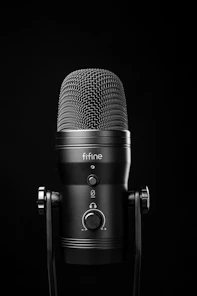 A black microphone on a stand against a black background