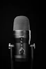 A black microphone on a stand against a black background