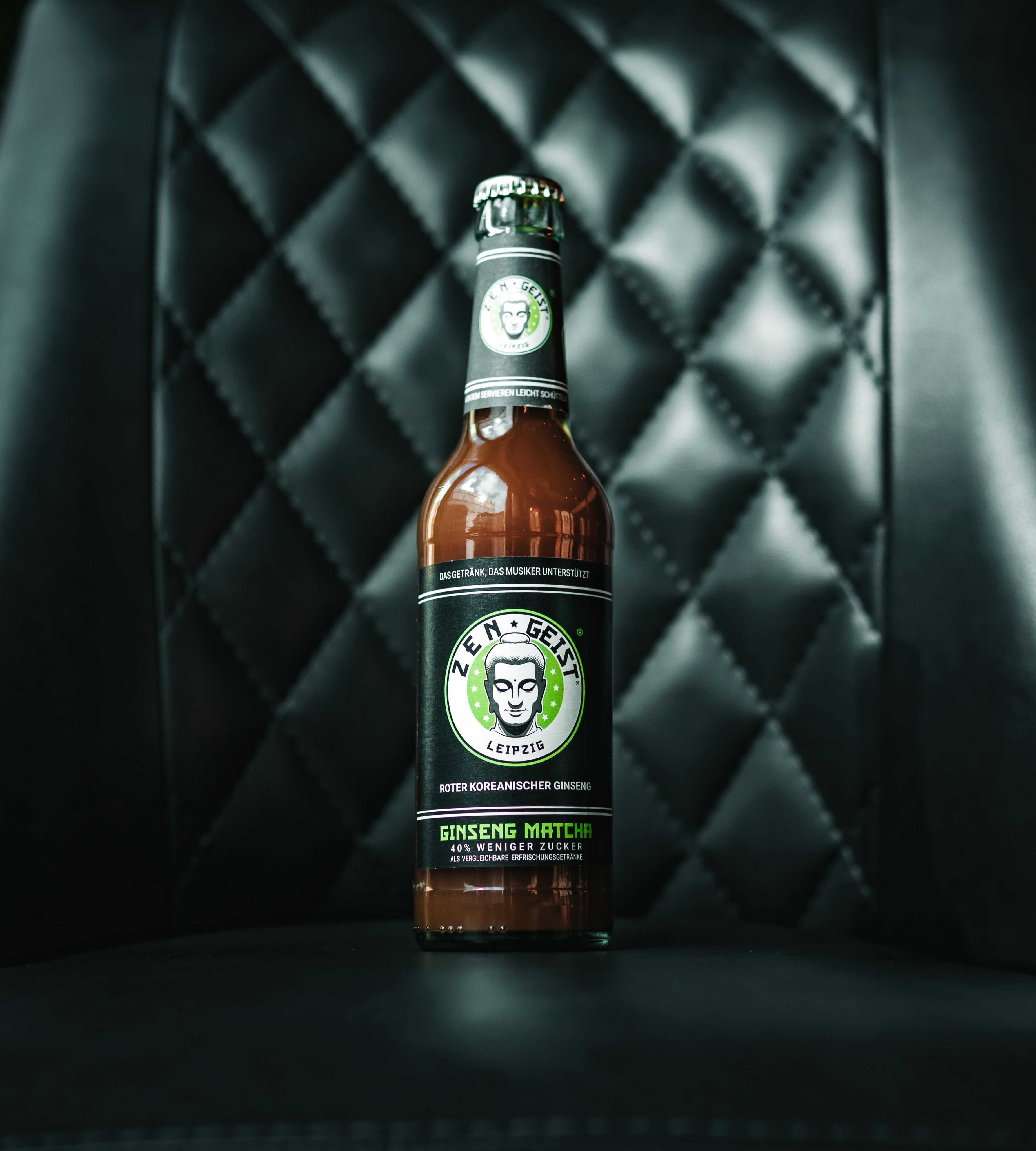 Una botella de cerveza encima de una silla negra