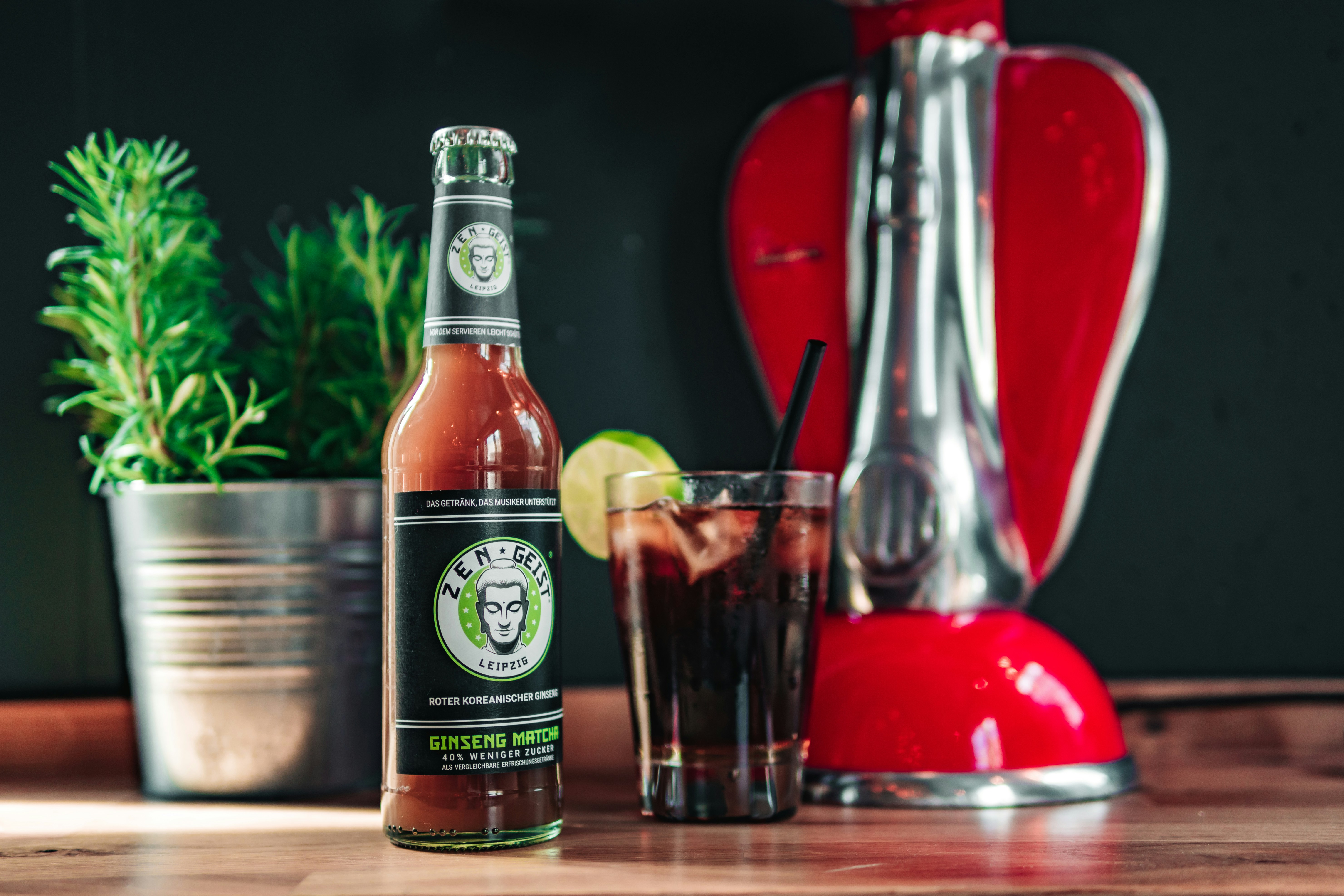 Una licuadora roja encima de una mesa de madera