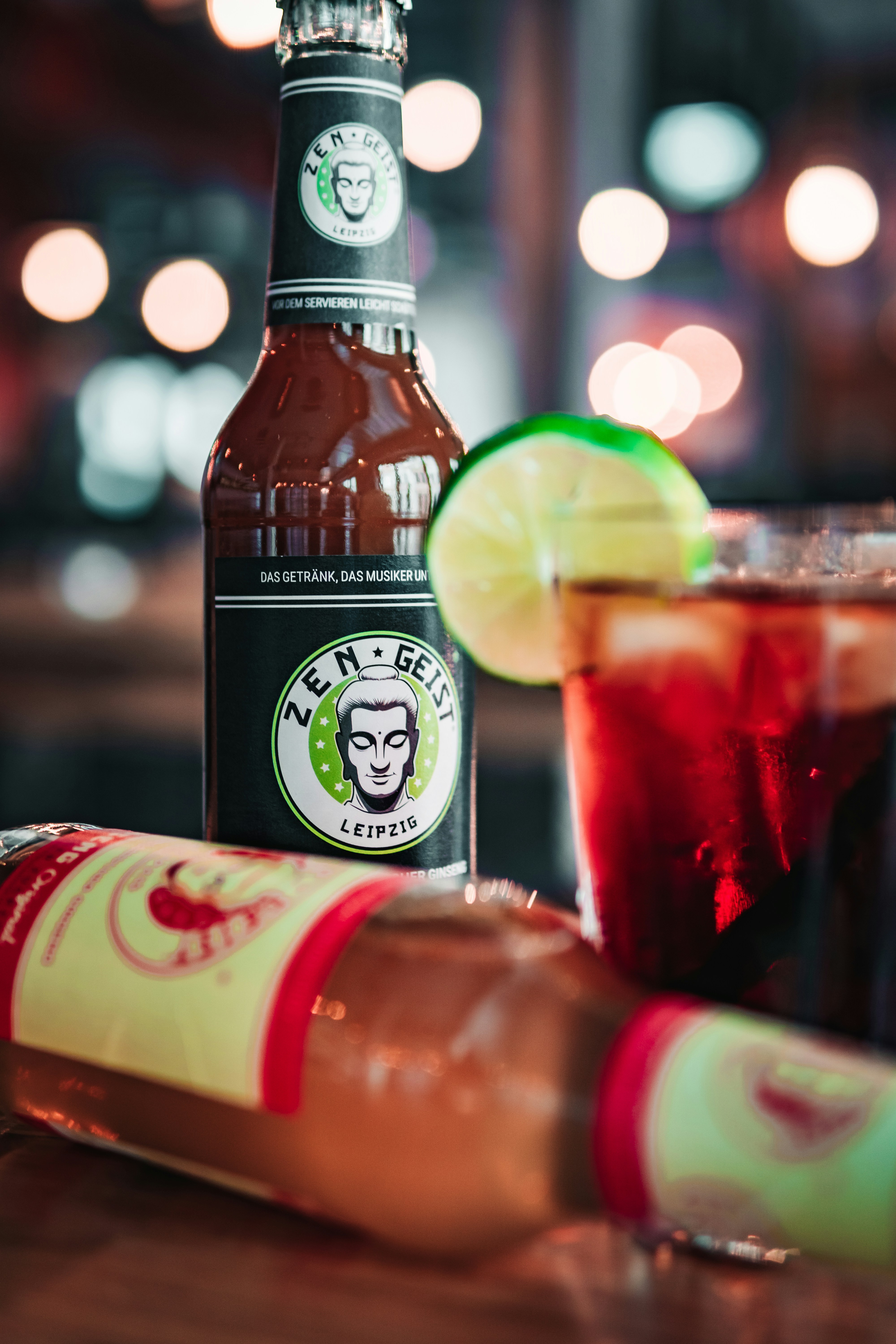 Una botella de cerveza junto a un vaso con una lima