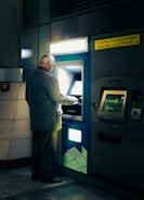A man standing in front of a atm machine