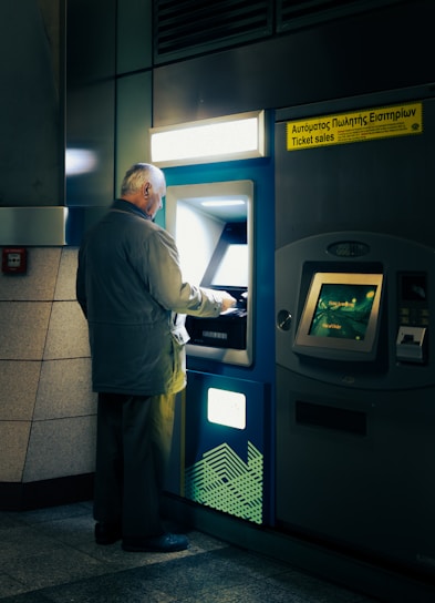 A man standing in front of a atm machine