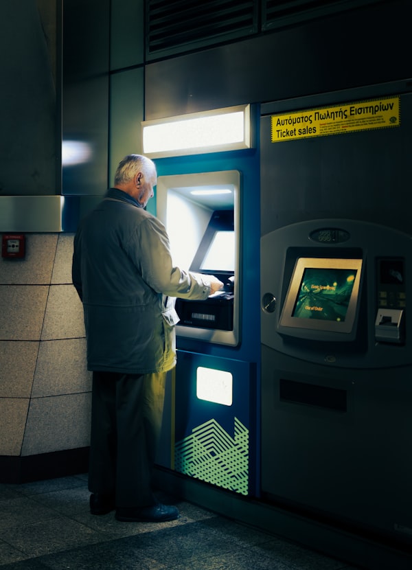 Person vor einem Geldautomaten in einer Bankfiliale