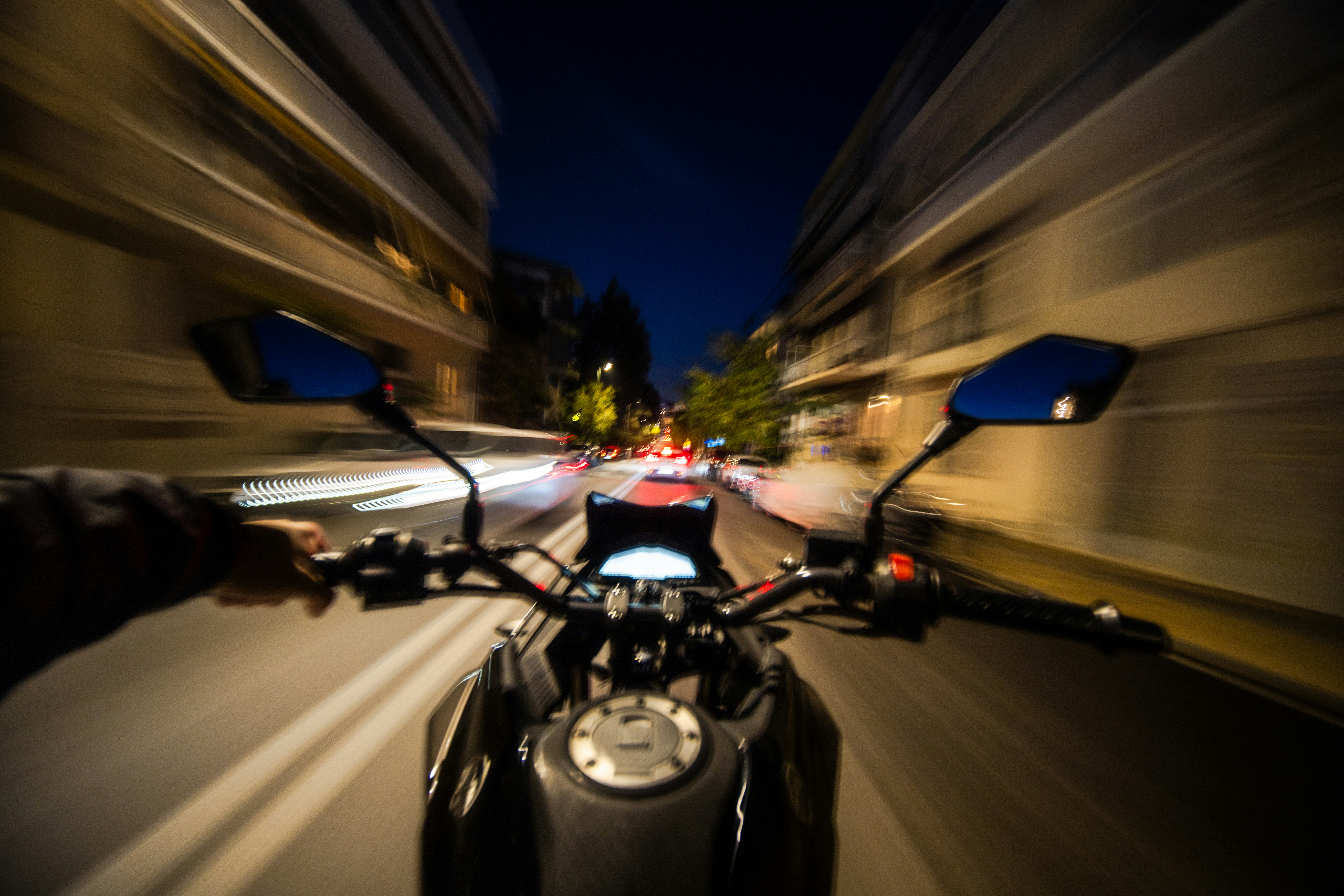 A person riding a motorcycle down a street at night